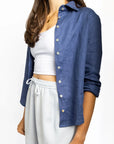 Person wearing a blue shirt over a white top and shorts on a white background