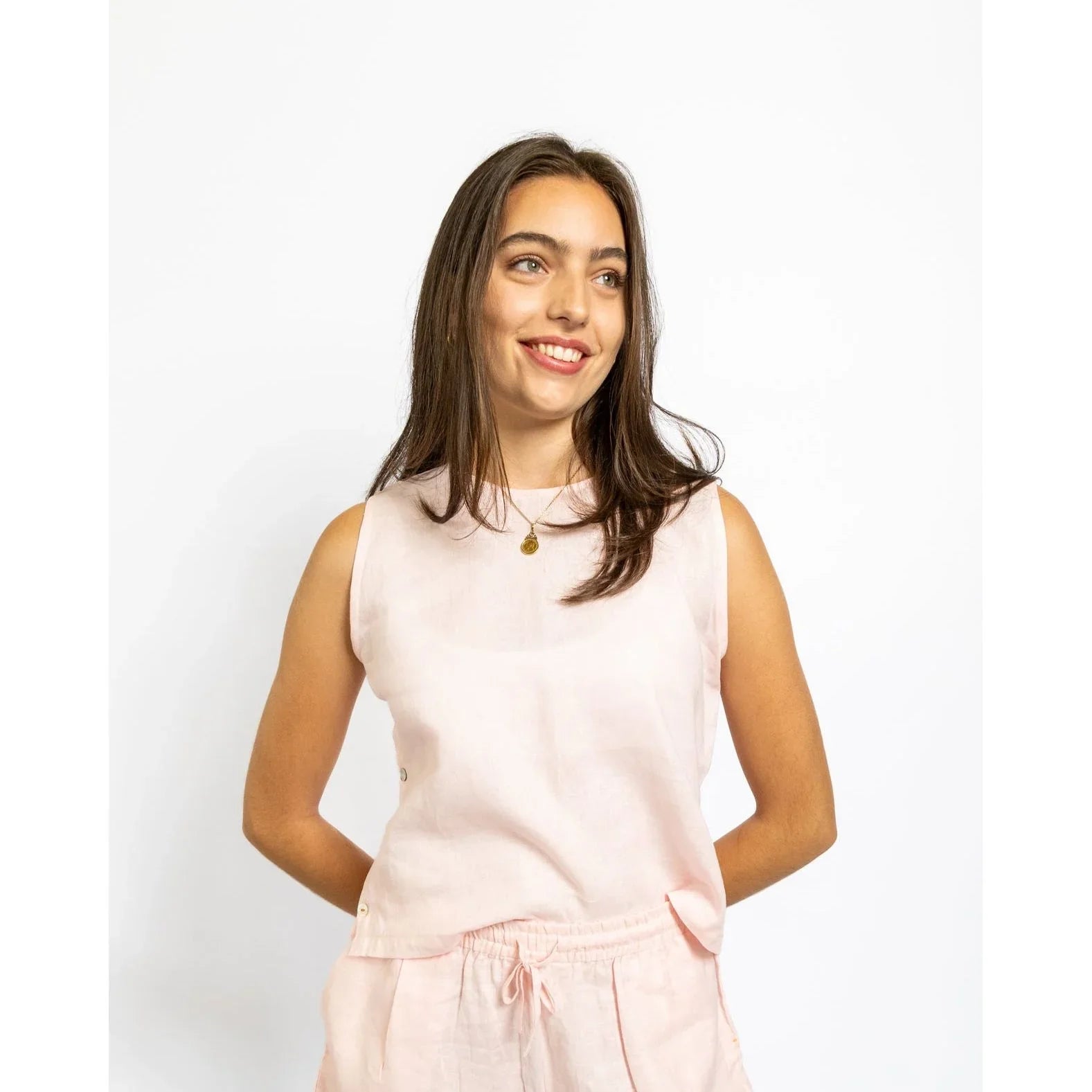 Woman wearing a light pink sleeveless top and shorts set on a white background