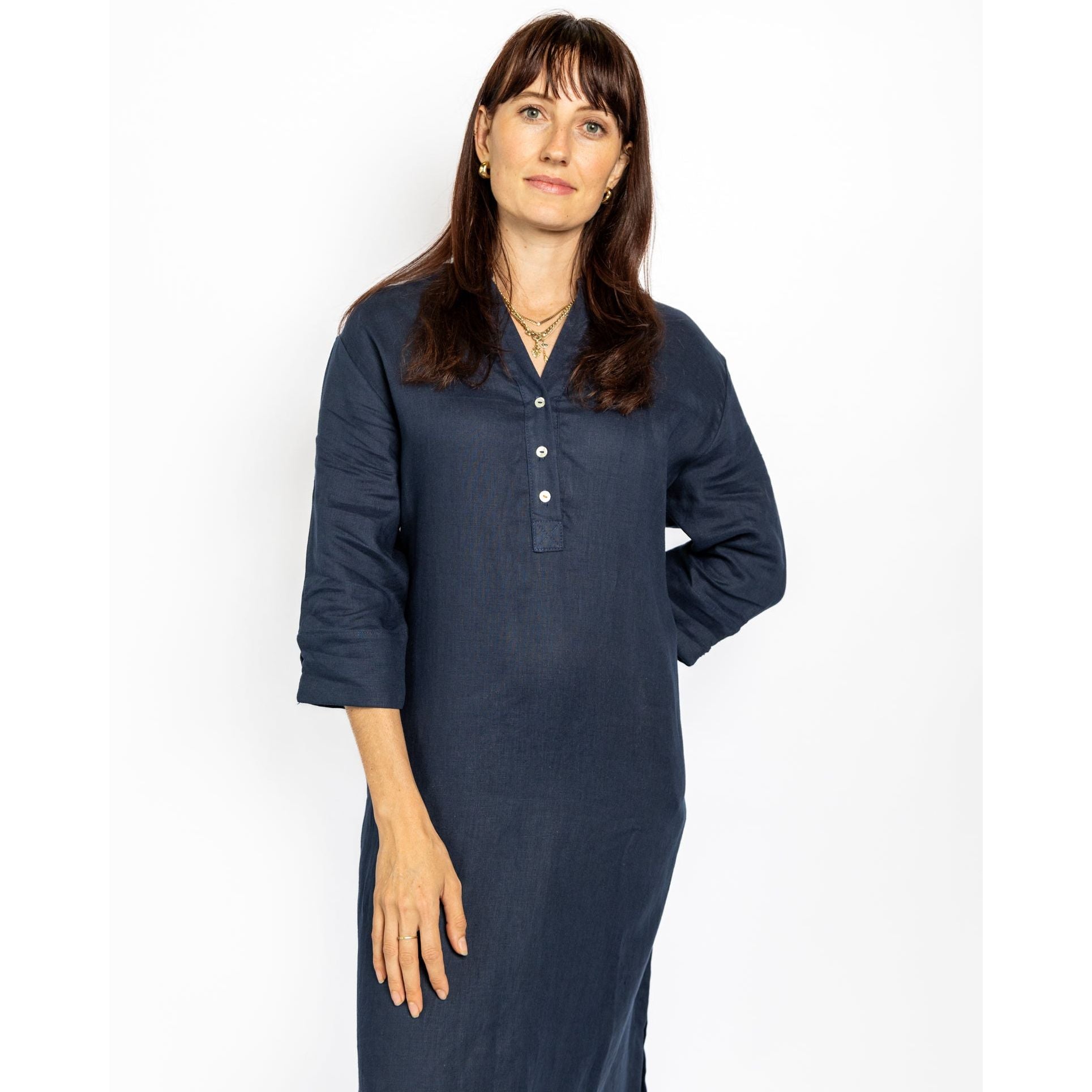 Woman wearing a long navy blue dress against a white background