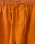 Close-up of orange pants with drawstring waistband